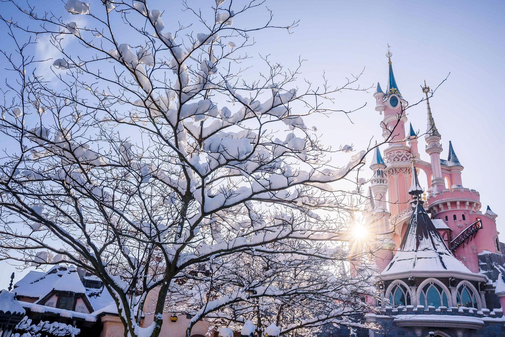 parco Disneyland Paris innevato e vista del Castello della Bella Addormentata con neve