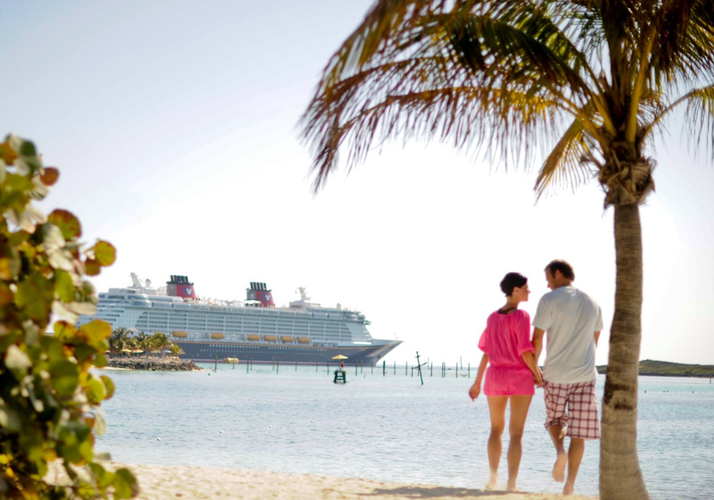 Coppia di fidanzati nella spiaggia delle Bermuda con la Disney Cruise Line in secondo piano