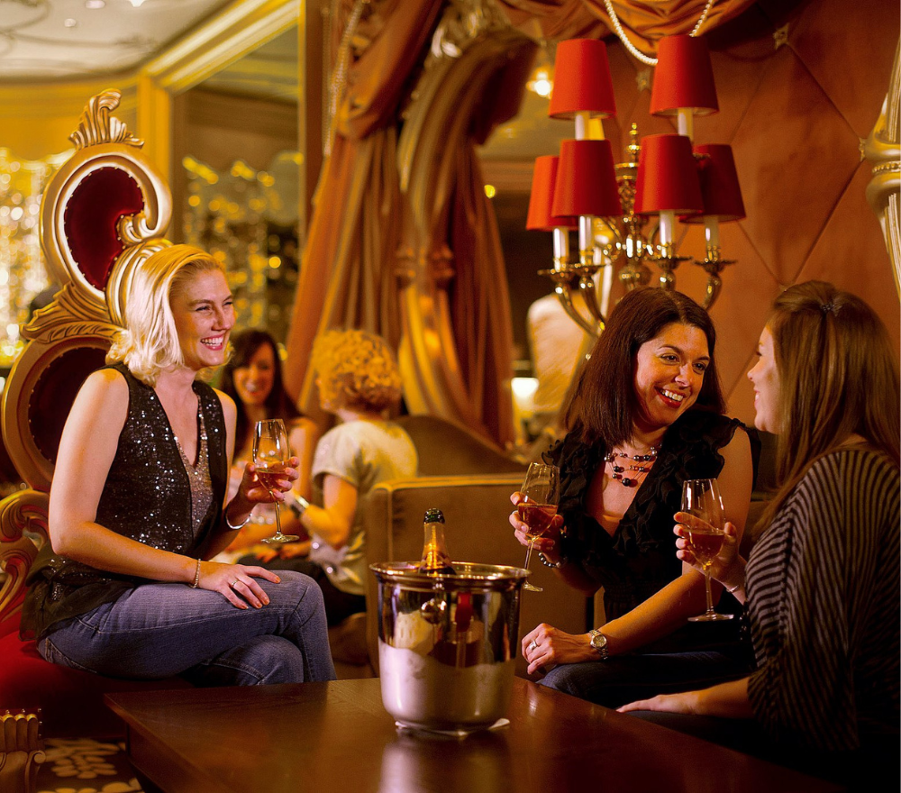 Tre ragazze ridono e bevono Champagne al Lounge Bar della Disney Cruise